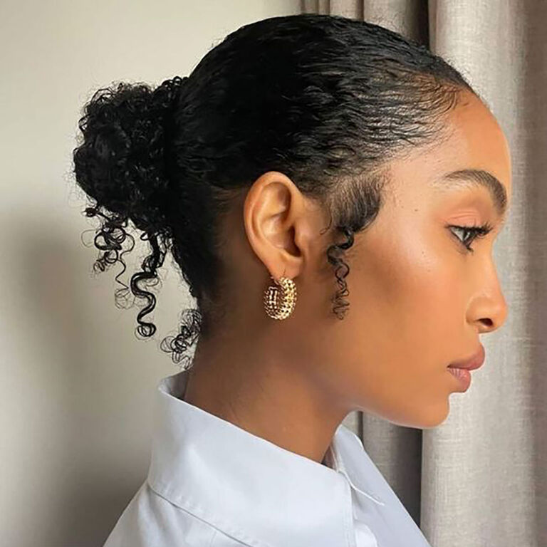Messy slicked bun sur cheveux fris&eacute;s